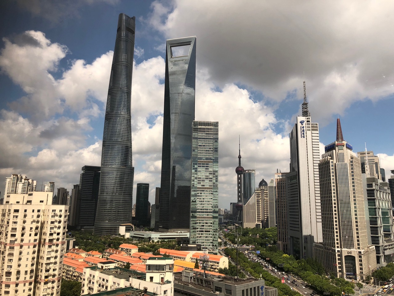 iRepChina office building, a tall, largely glass skyscraper in Shanghai, visible here on a blue sky day